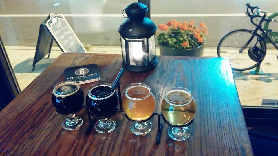 Flight of four beers and a lantern on a wooden window-side table