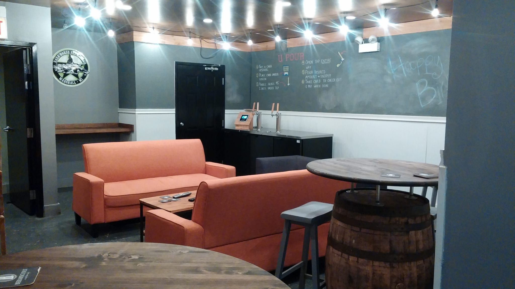 Lounge with orange sofas, self-pour taps and a barrel-base table