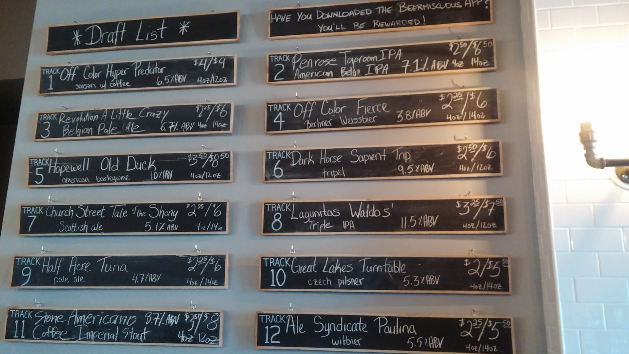 Wall of chalkboard draft list panels listing beers, styles and prices