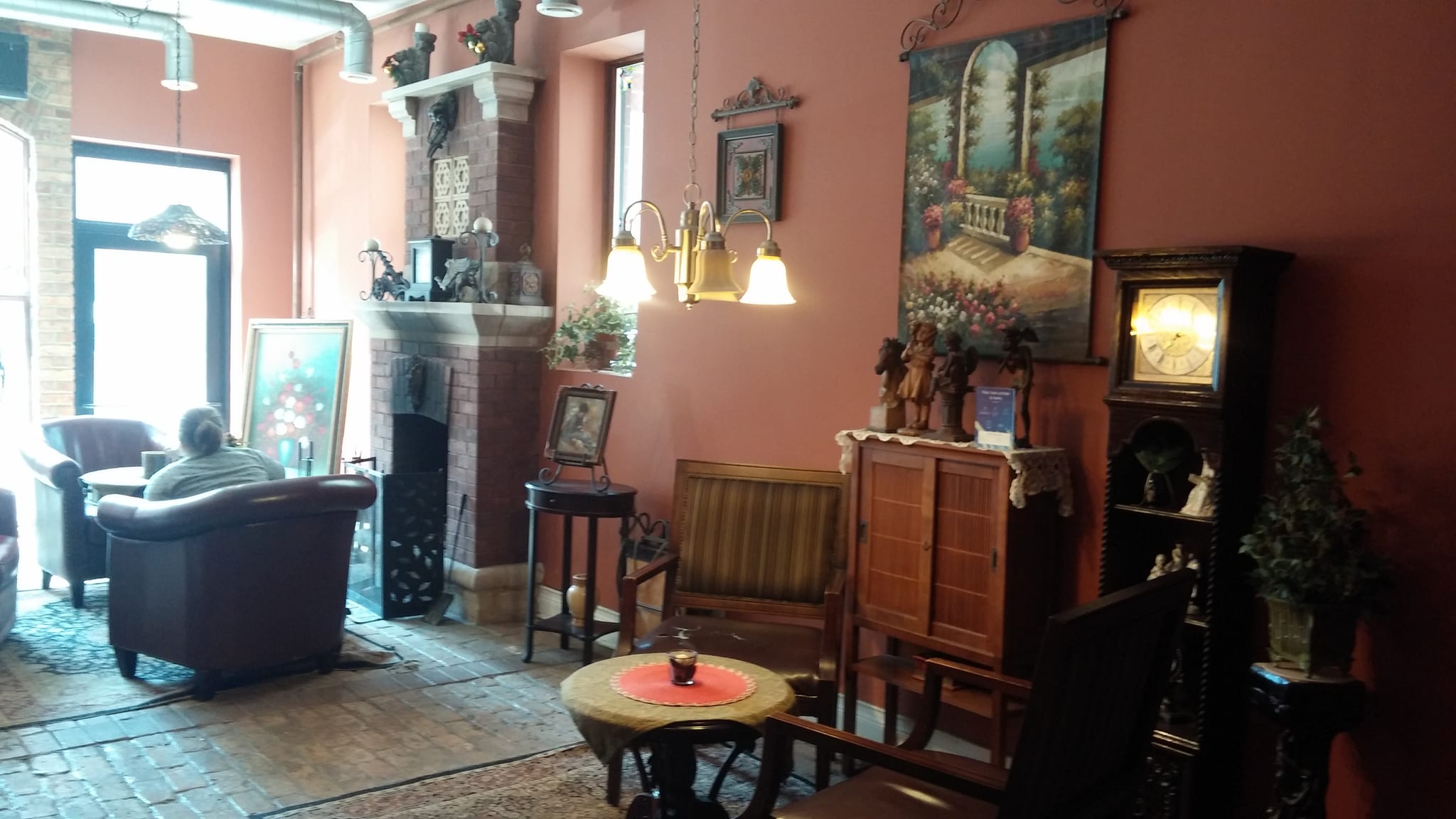 Parlor seating with leather armchairs, brick fireplace and grandfather clock