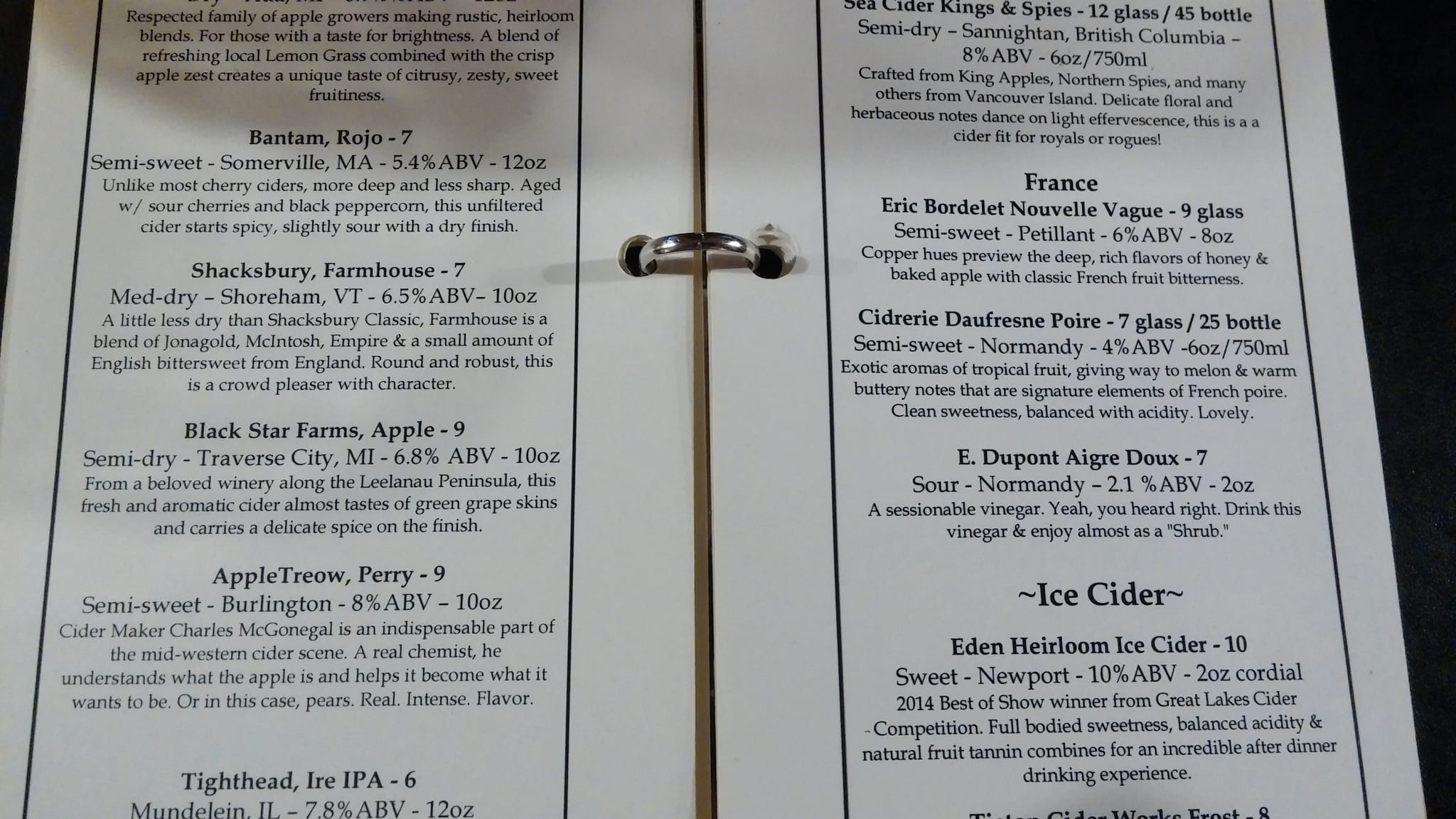 Open printed cider list describing ciders by region, ABV and price