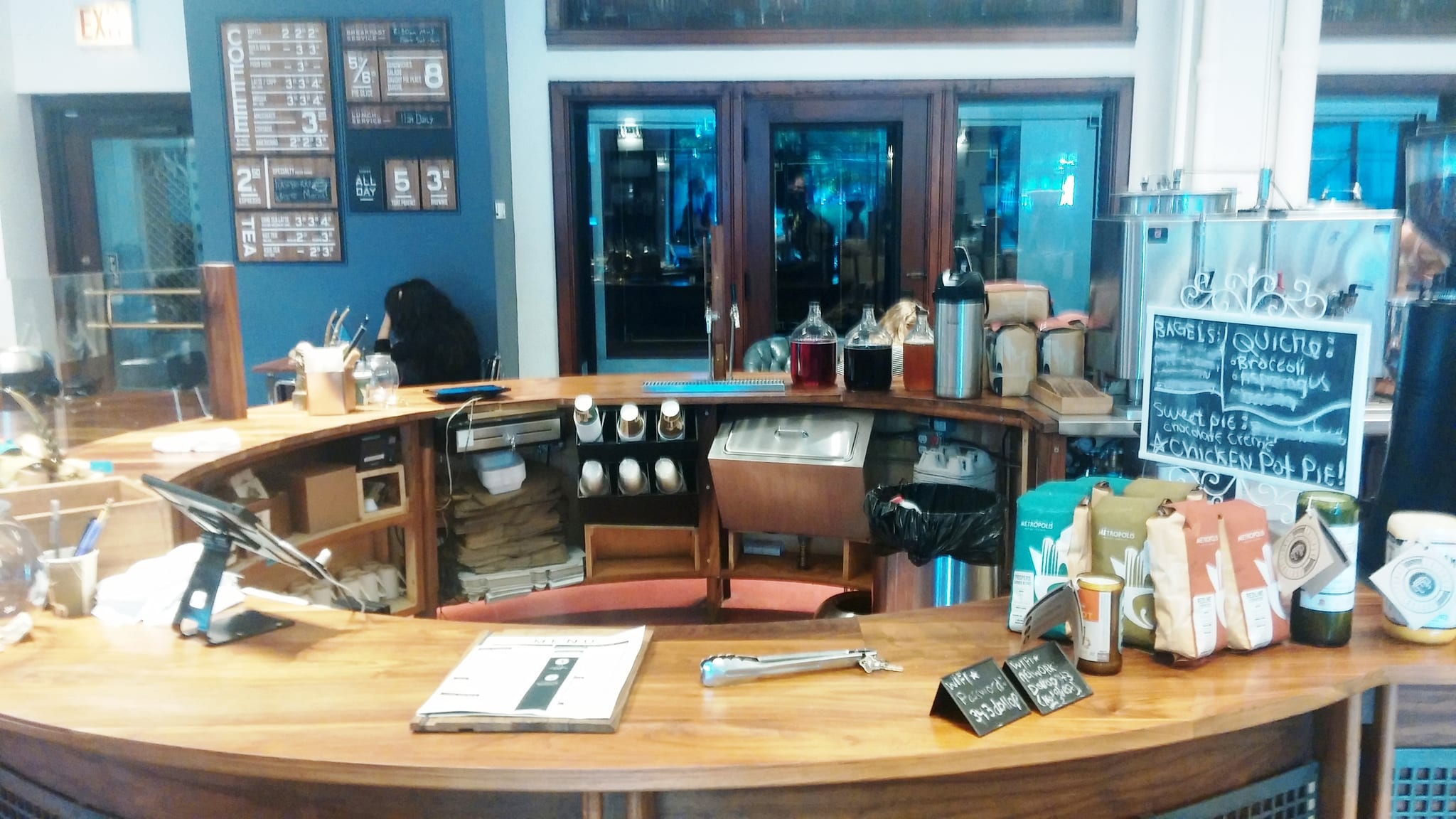 Curved wood service counter with menu boards and bagged coffee for sale