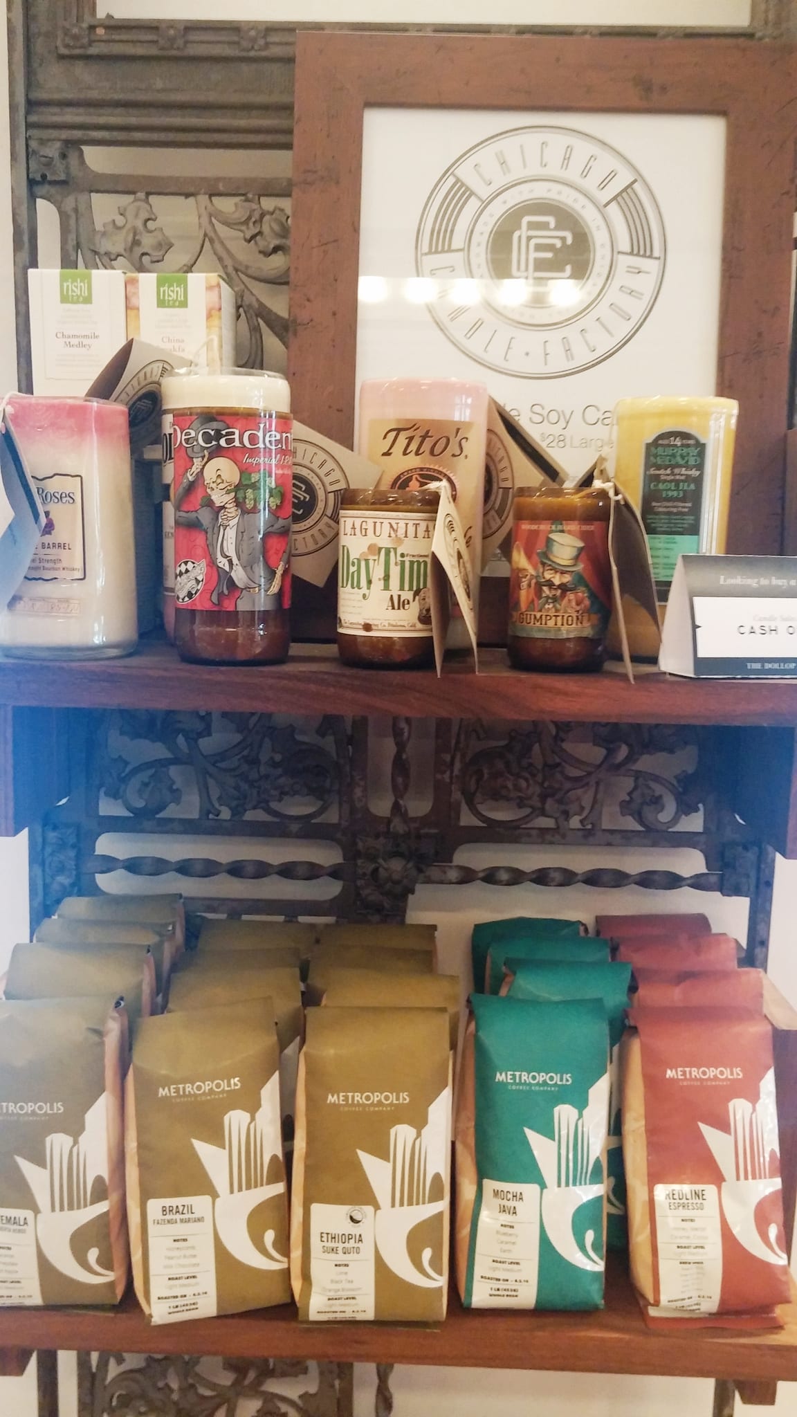 Retail shelves of candles above rows of Metropolis coffee bags