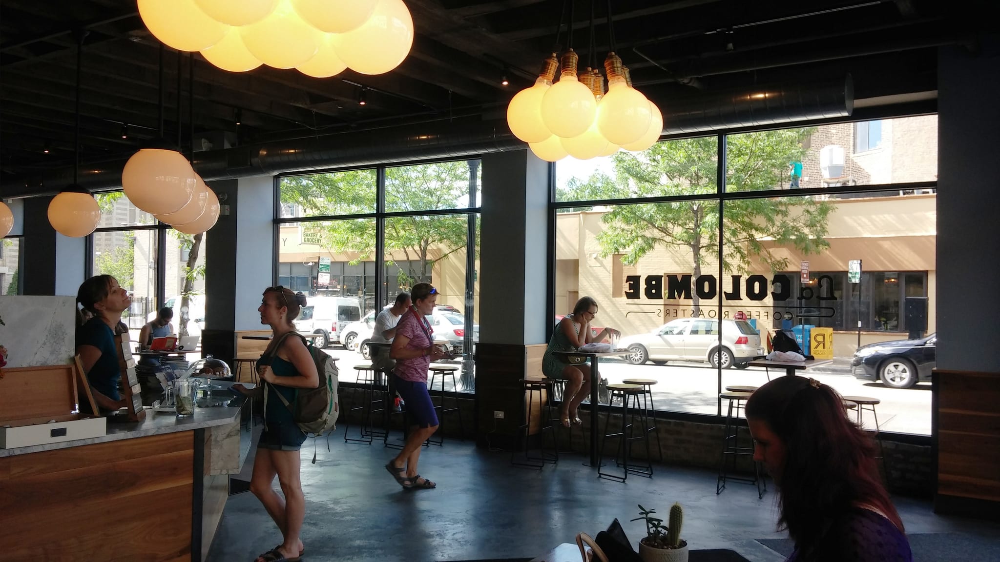 Airy cafe with globe pendant lights, window bar stools and street view