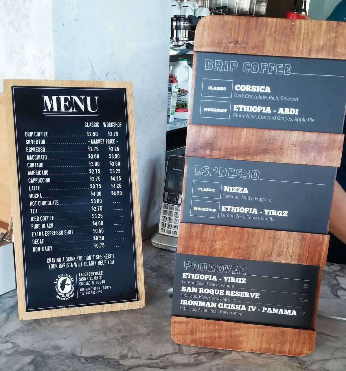 Chalkboard menus listing drip coffee, espresso and pourover offerings with prices