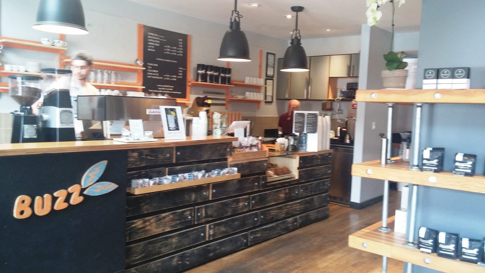 Espresso counter with grinders, chalkboard menu and retail coffee bags
