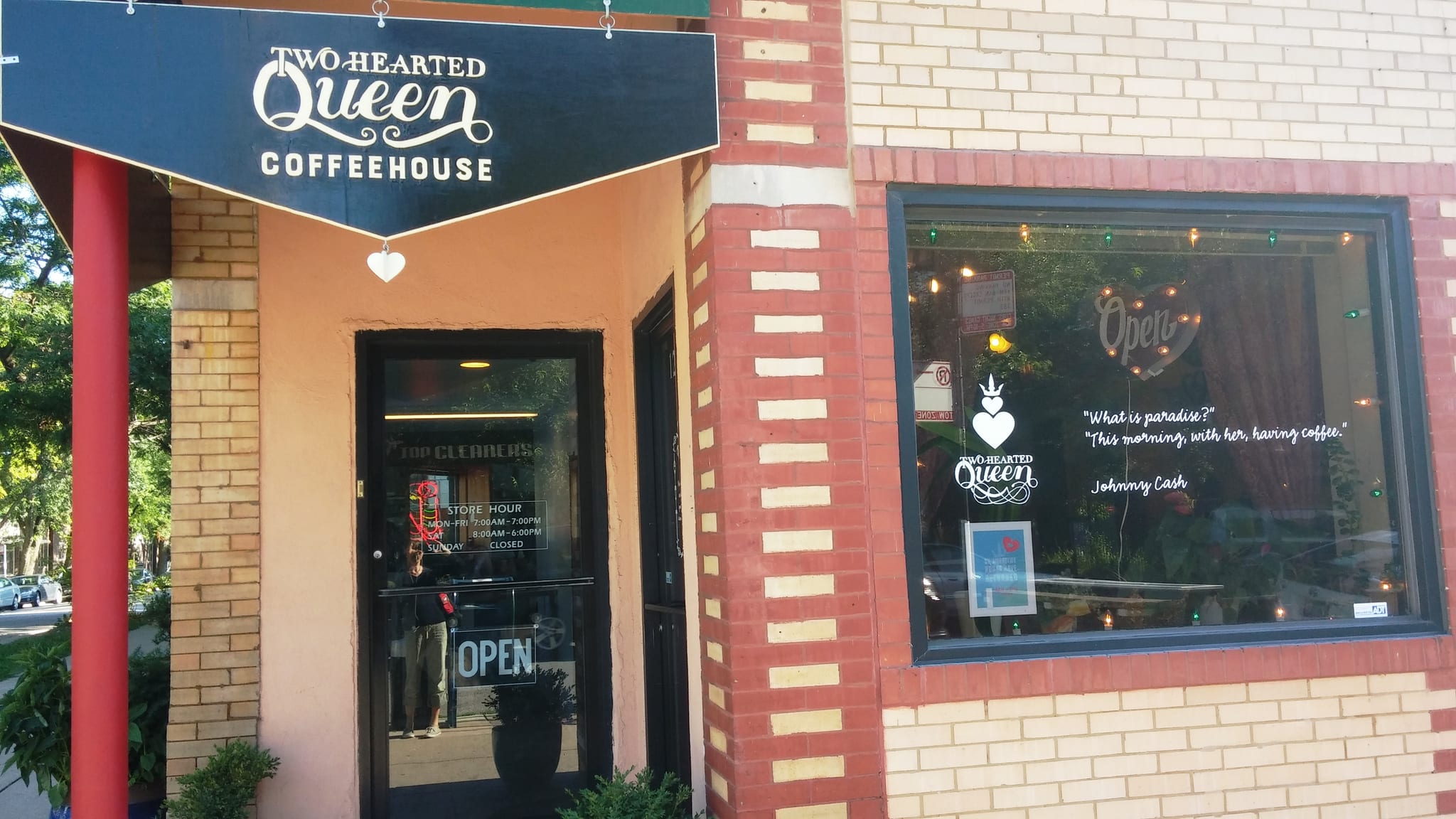 Brick corner storefront with Two Hearted Queen Coffeehouse sign and Open window