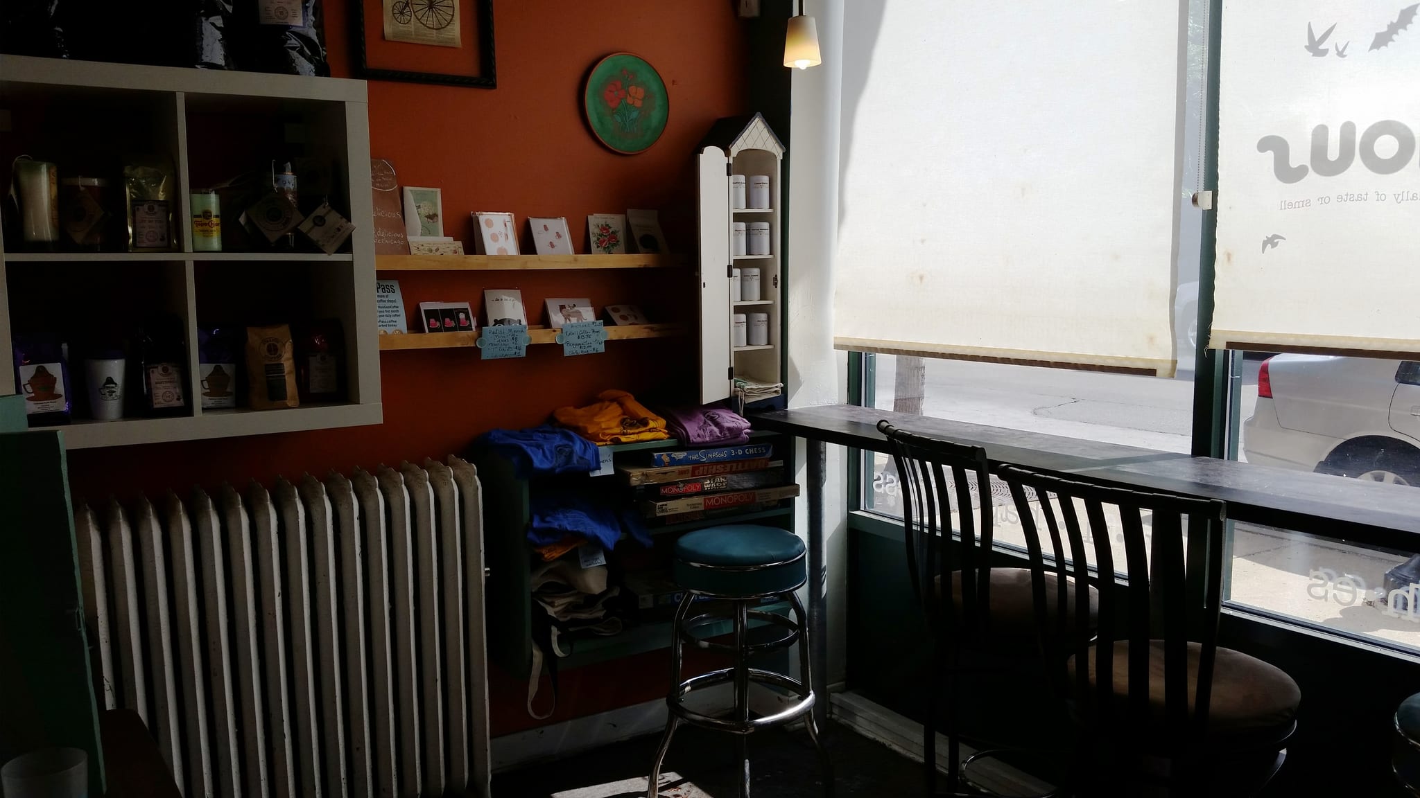 Window bar with stools, retail shelves and board games by radiator