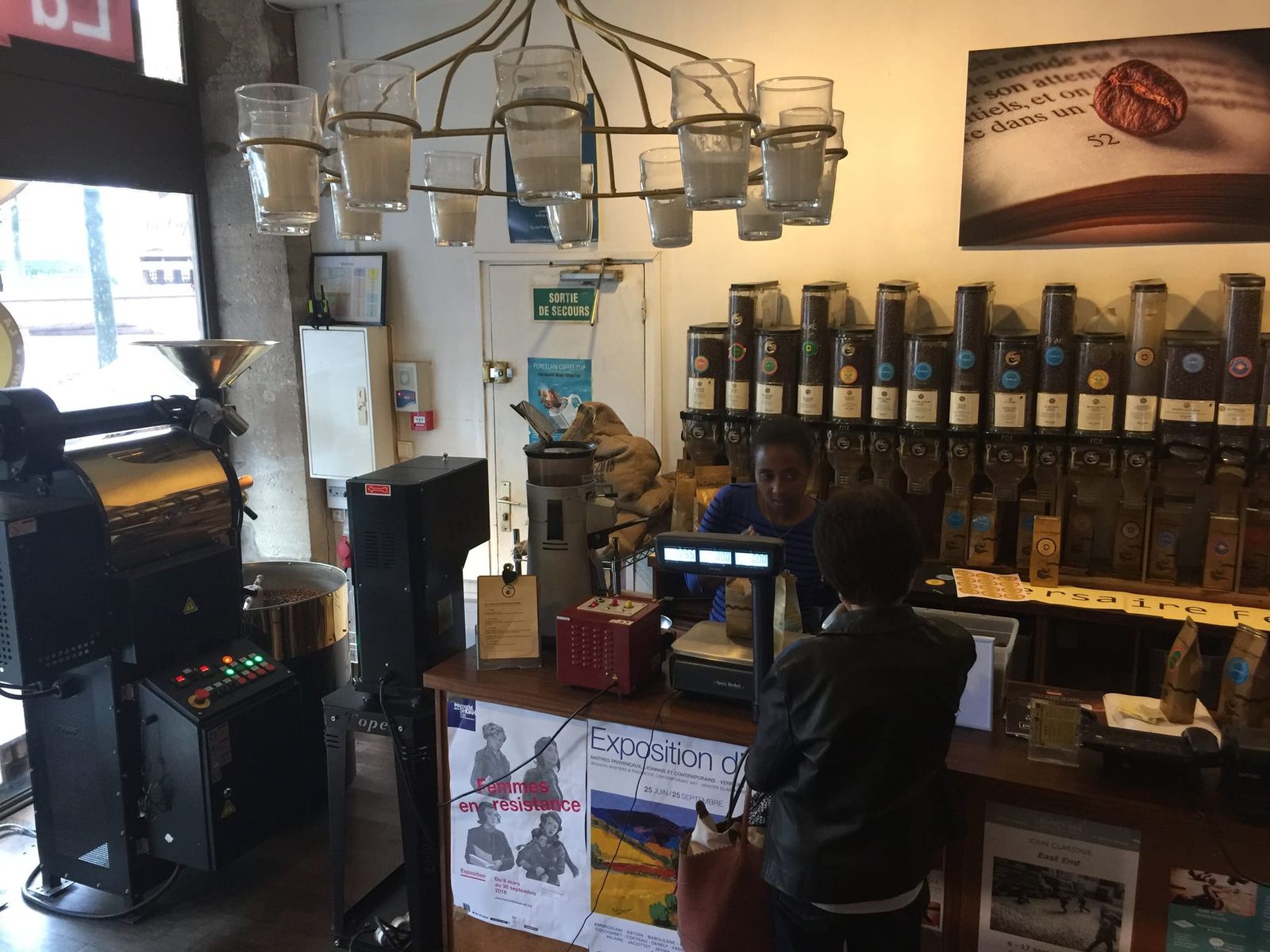 Drum roaster and coffee bean dispensers behind a weighing scale