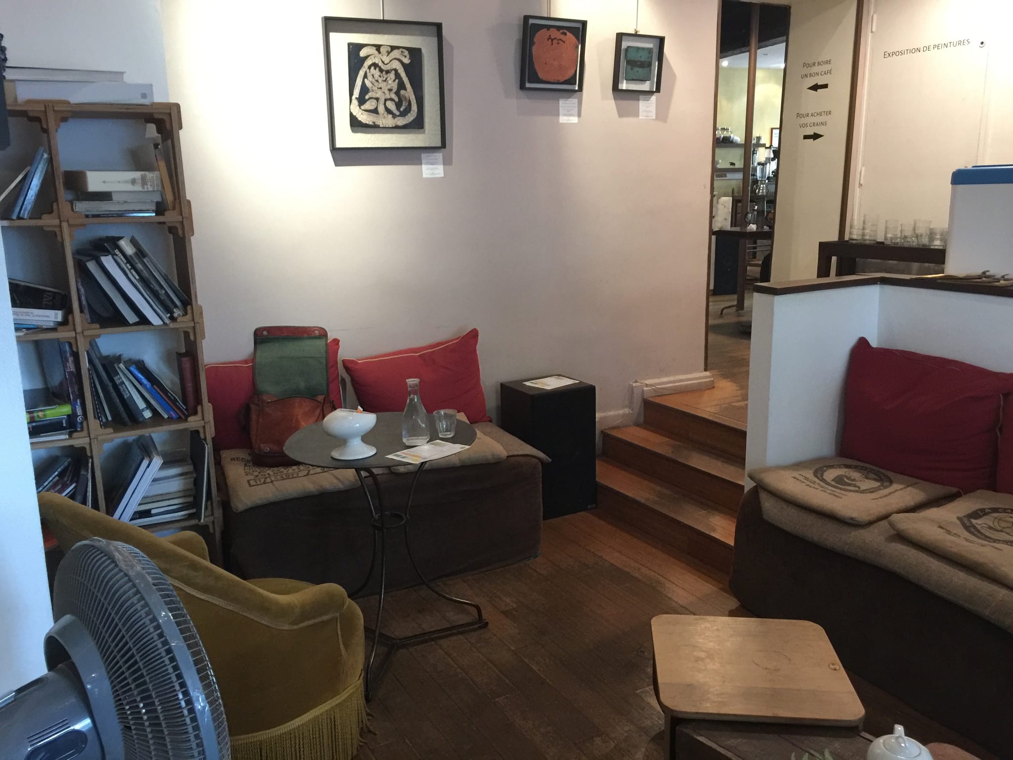 Lounge corner with bookshelves, red cushions and burlap sack seating