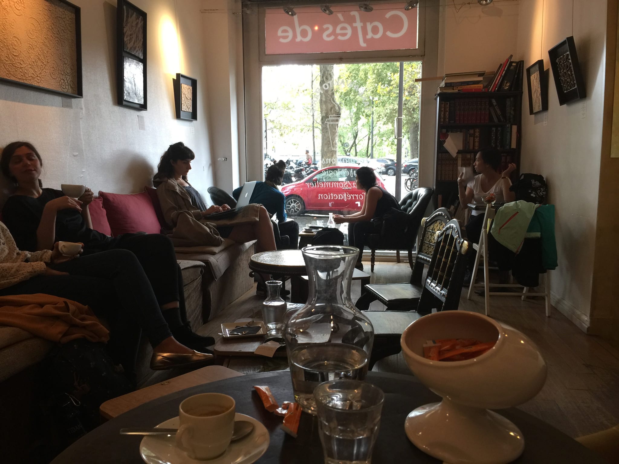 Guests on sofas facing a lettered street window