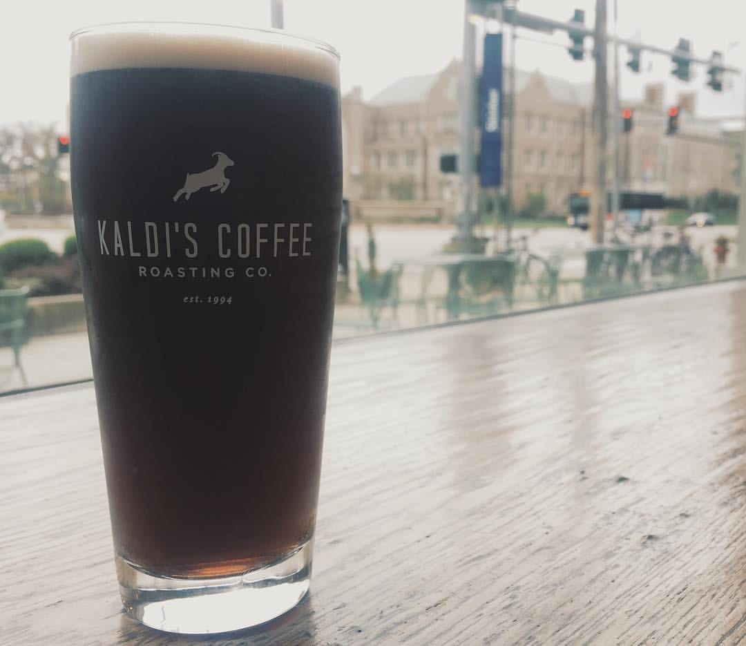 Tall glass of dark cold brew on wooden window ledge