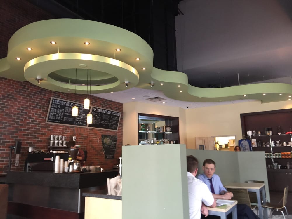 Two men talking at table beneath curving pale green ceiling
