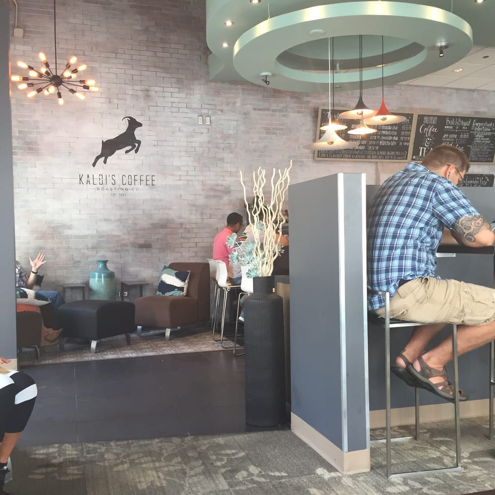 Customers on stools at window bar near sputnik style chandelier