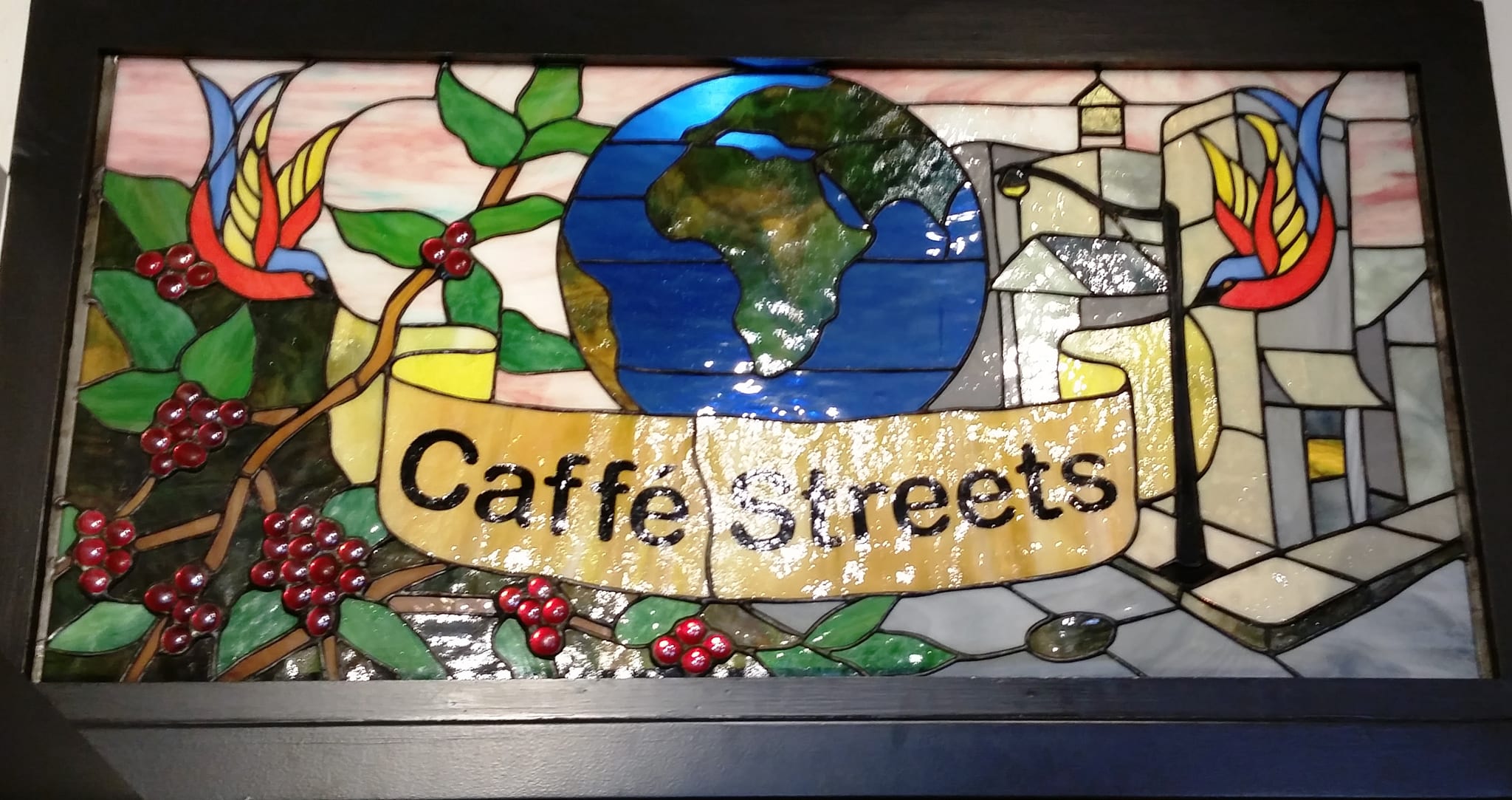 Stained glass panel with globe, coffee cherries and Caffe Streets banner