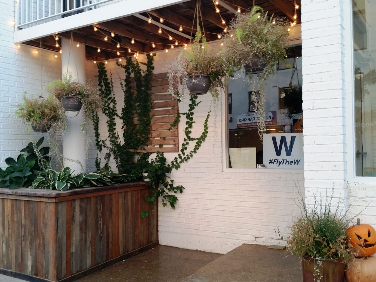 Sidewalk pallet benches cushioned with burlap coffee sacks and marble bistro tables