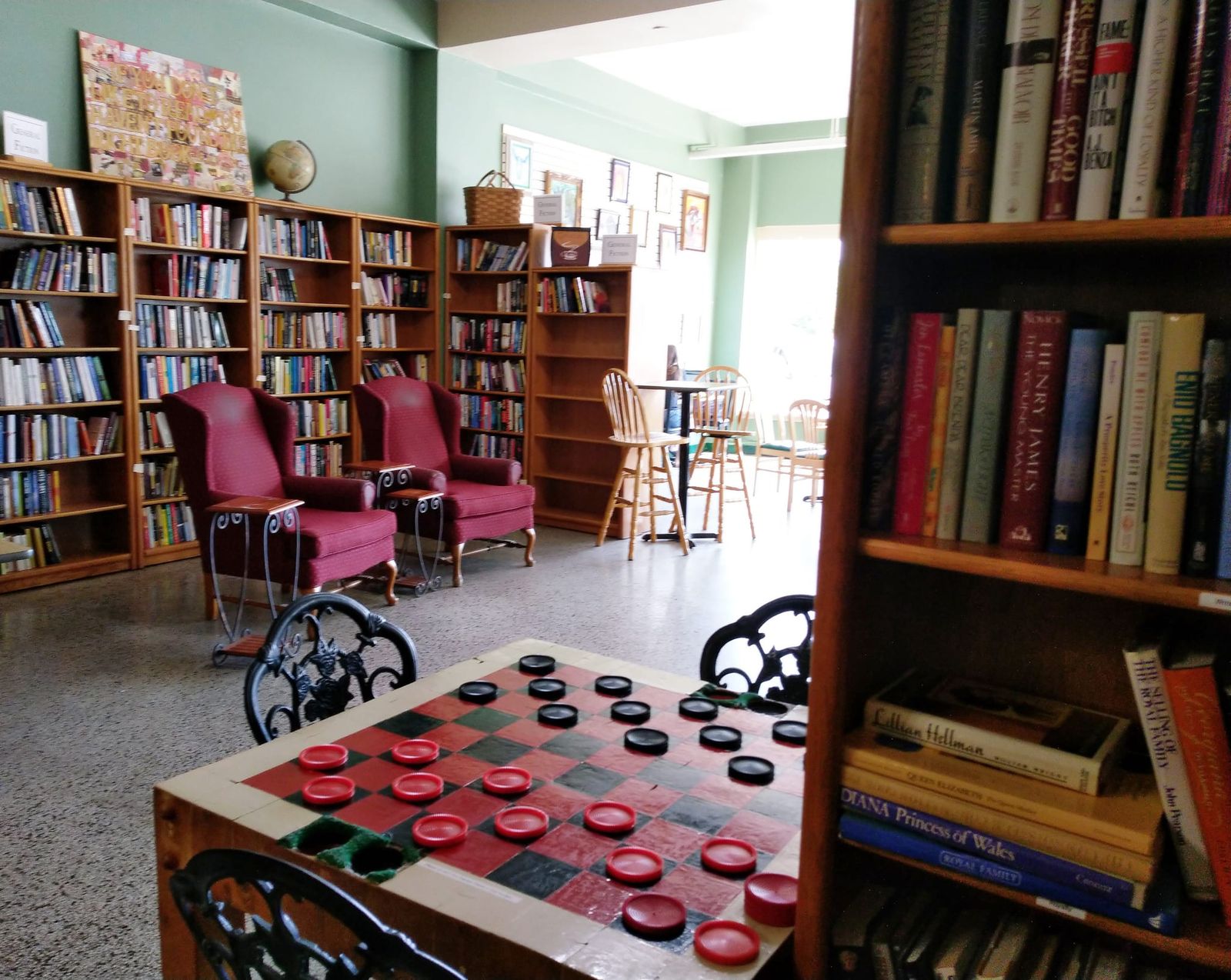 Bookshelves, red wingback armchairs, and an oversized checkers table