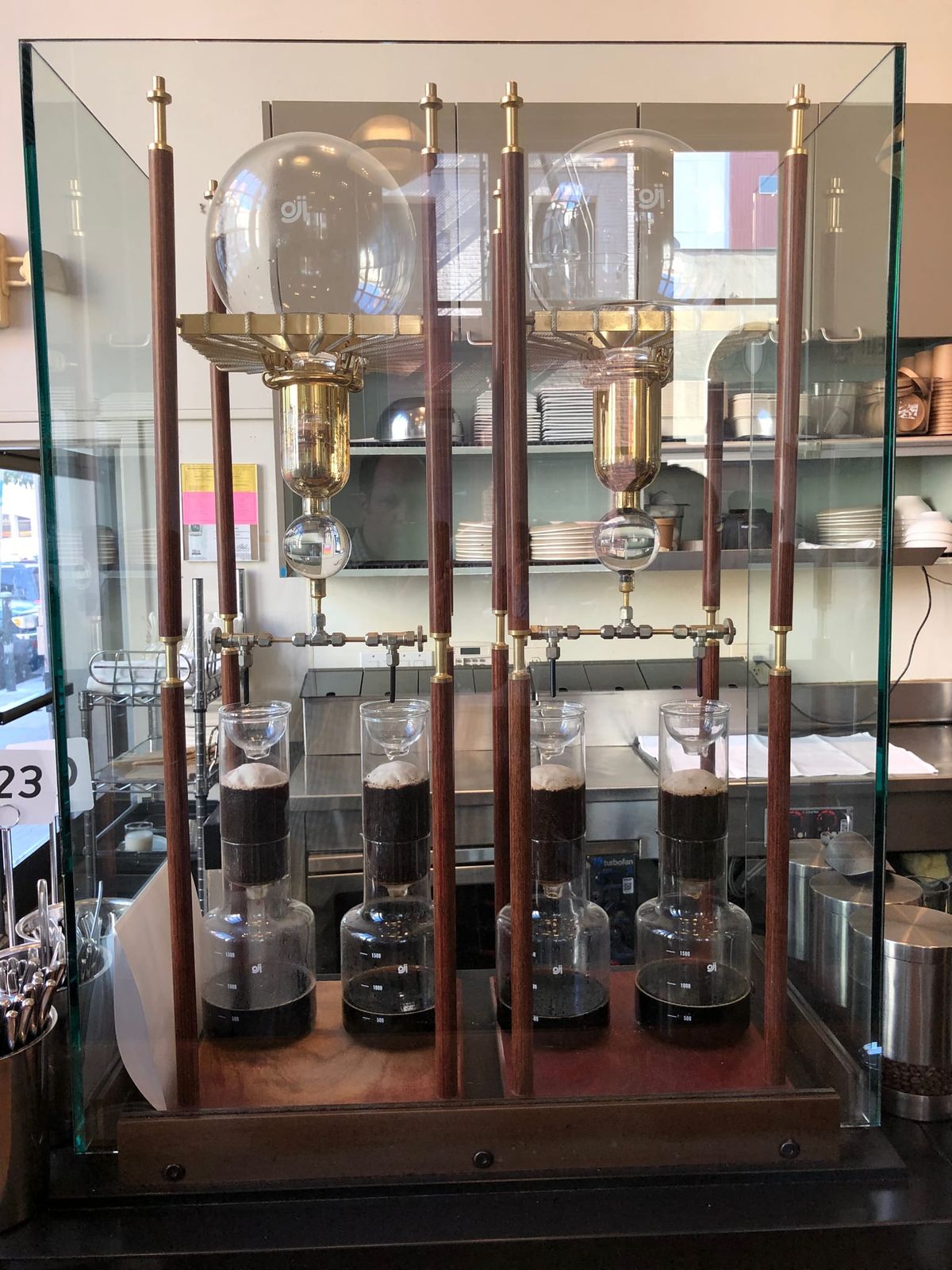 Brass and glass slow drip cold brew towers in a display case